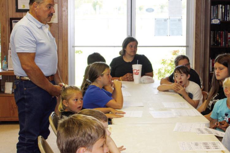Children roll fingerprints onto worksheets and pick out books at Midway City Hall during the third Friday of the city’s summer reading program. Prairie View A&amp;M extension agents Chandra Adams and Shannon Dietz led the morning with a lesson on forensic science, showing the kids how the marks on their fingers can be identified. METEOR PHOTOS BY RICHARD SIRMAN